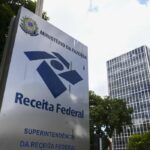 Prazo para aderir ao Simples Nacional termina neste sábado Pedido é feito online e vale para MEI, micro e pequenas empresas Wellton Máximo – Repórter da Agência Brasil Publicado em 31/01/2026 - 07:32 Brasília Superintendência da Receita Federal, em Brasília.© Marcelo Camargo/Agência Brasil Versão em áudio Empreendedores que desejam aderir ou regressar ao Simples Nacional têm até este sábado (31) para fazer o pedido. O prazo vale tanto para empresas que nunca optaram pelo regime quanto para aquelas que foram excluídas e querem reingressar. Regime que permite o pagamento de tributos de forma simplificada, o Simples é destinado a microempreendedores individuais (MEI), microempresas (ME) e empresas de pequeno porte (EPP). Para optar pelo regime, a empresa precisa ter o Cadastro Nacional da Pessoa Jurídica (CNPJ), inscrição municipal e, quando exigível, inscrição estadual. O pedido é feito exclusivamente pela internet, no Portal do Simples Nacional, com acesso por certificado digital ou código de acesso. Após o pedido, o sistema faz uma verificação automática de pendências com a Receita Federal, os estados e os municípios. Se não houver irregularidades, a opção é aprovada. Caso existam débitos ou inconsistências, o pedido fica “em análise” até a regularização. O acompanhamento pode ser feito no próprio portal. O resultado dos pedidos está previsto para ser divulgado na segunda quinzena de fevereiro. Empresas que já estão no Simples e não foram excluídas permanecem automaticamente no regime, sem necessidade de novo pedido. Entre os principais motivos de exclusão estão débitos tributários, excesso de faturamento, falta de documentos, parcelamentos pendentes e o exercício de atividades não permitidas. Dívidas de empresas Empresas excluídas por dívidas podem voltar ao Simples desde que regularizem todas as pendências até 31 de janeiro e façam novo pedido. A Receita Federal permite a regularização por meio de pagamento à vista, parcelamentos ou transações. Se o pedido for aprovado, o retorno ao regime tem efeito retroativo a 1º de janeiro. Débitos com a Receita Federal devem ser negociados pelo Portal do Simples Nacional; dívidas inscritas na Dívida Ativa da União, pelo Portal Regularize. Pendências estaduais ou municipais devem ser resolvidas diretamente com o órgão local. Quem perder o prazo só poderá pedir nova adesão em janeiro de 2027. Nesse período, a empresa passa a outro regime de tributação, como Lucro Presumido ou Lucro Real. Situação dos MEI Os MEI excluídos do Simples e desenquadrados do Simei também têm até 31 de janeiro para regularizar pendências e pedir o retorno. O primeiro passo é verificar a situação do CNPJ no Portal do Simples. Em seguida o microempreendedor deve quitar ou parcelar débitos no Centro Virtual de Atendimento da Receita (e-CAC), com acesso via Gov.br. Após regularizar os débitos, o MEI deve pedir a opção pelo Simples Nacional e, em seguida, o reenquadramento no Simei. Os pedidos são analisados de forma sequencial, e o enquadramento como MEI depende, obrigatoriamente, da aprovação prévia no Simples Nacional. O Ministério do Empreendedorismo recomenda o acompanhamento diário do pedido, já que eventuais pendências apontadas durante a análise precisam ser resolvidas dentro do prazo legal para garantir a volta ao regime simplificado ainda neste ano.